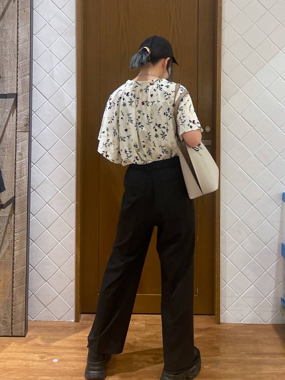 ブラック系のスニーカー、ベージュ系のビジネスバッグ、ホワイト系のシャツ/ブラウスを着用したレディースの春コーディネートの3枚目の写真