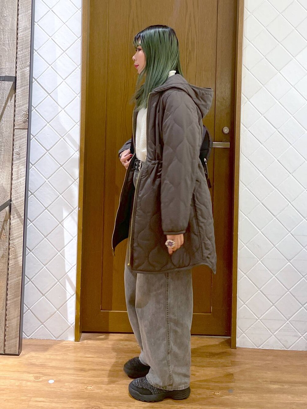 グリーン系のその他アウター、グレー系のデニムパンツ、ブラック系のブーツを着用したレディースの冬コーディネートの3枚目の写真