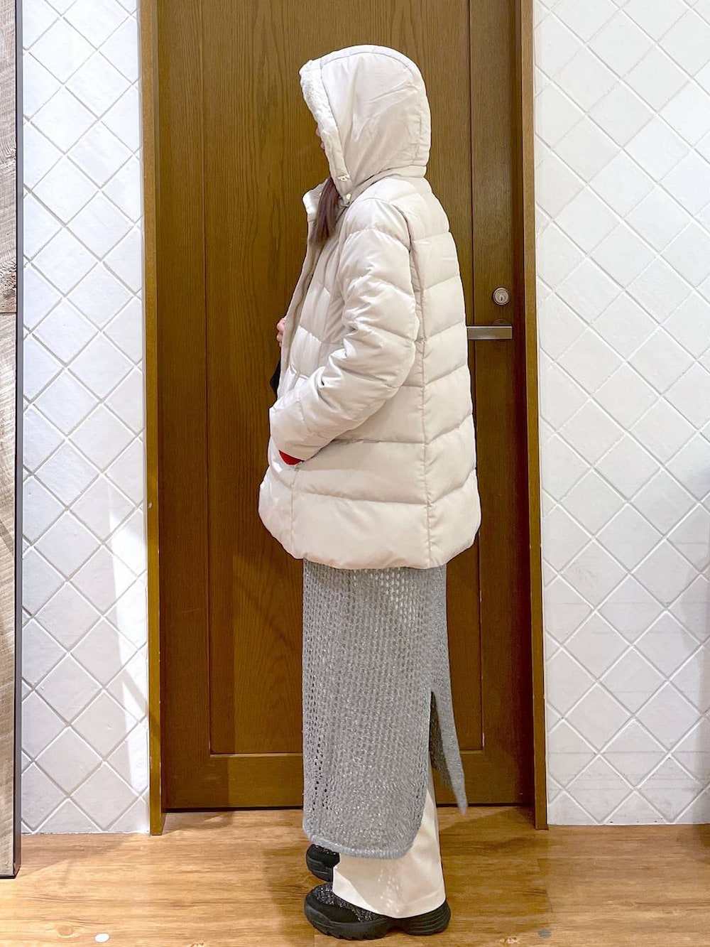 ホワイト系のその他パンツ、ベージュ系のダウンジャケット/コート、レッド系のニット/セーターを着用したレディースの秋コーディネートの6枚目の写真