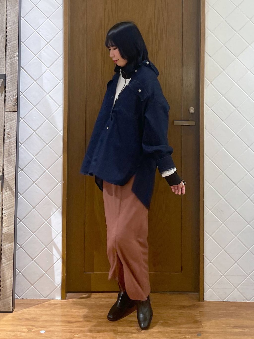 ブルー系のシャツ/ブラウス、ブラック系のブーツ、ピンク系のスカートを着用したレディースの春コーディネートの2枚目の写真