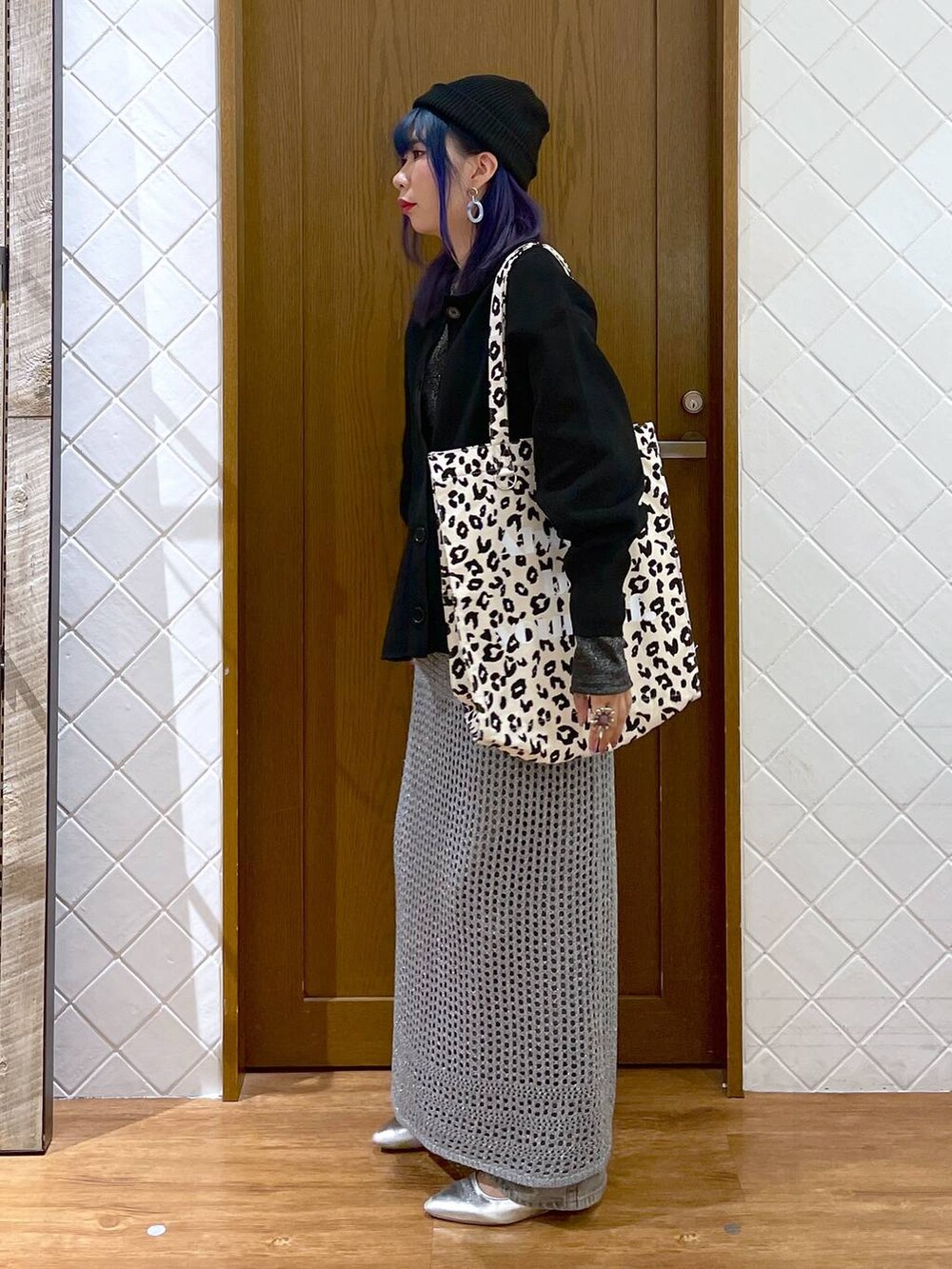 グレー系のデニムパンツ、ブラウン系のトートバッグ、シルバー系のパンプスを着用したレディースの秋コーディネートの2枚目の写真