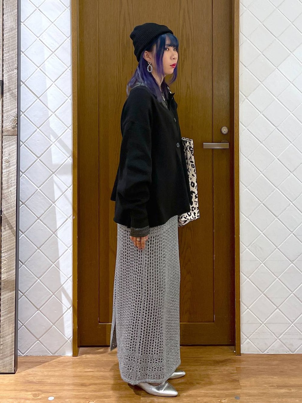 グレー系のデニムパンツ、ブラウン系のトートバッグ、シルバー系のパンプスを着用したレディースの秋コーディネートの3枚目の写真