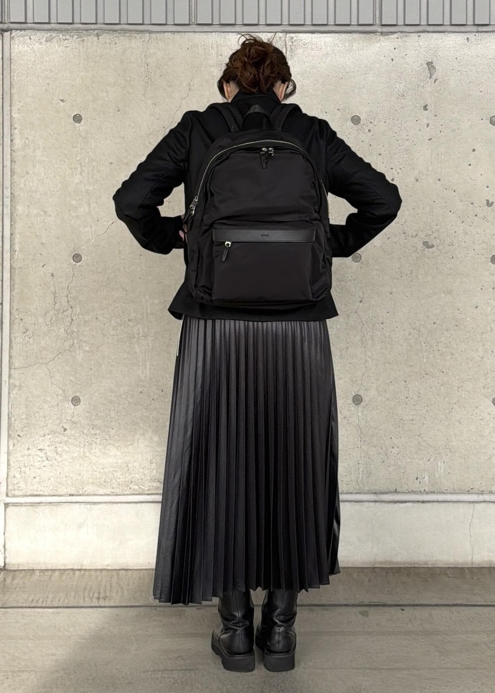 ブラック系のバックパック/リュック、ブラック系のスカート、ブラック系のニット/セーターを着用したレディースの冬コーディネートの7枚目の写真