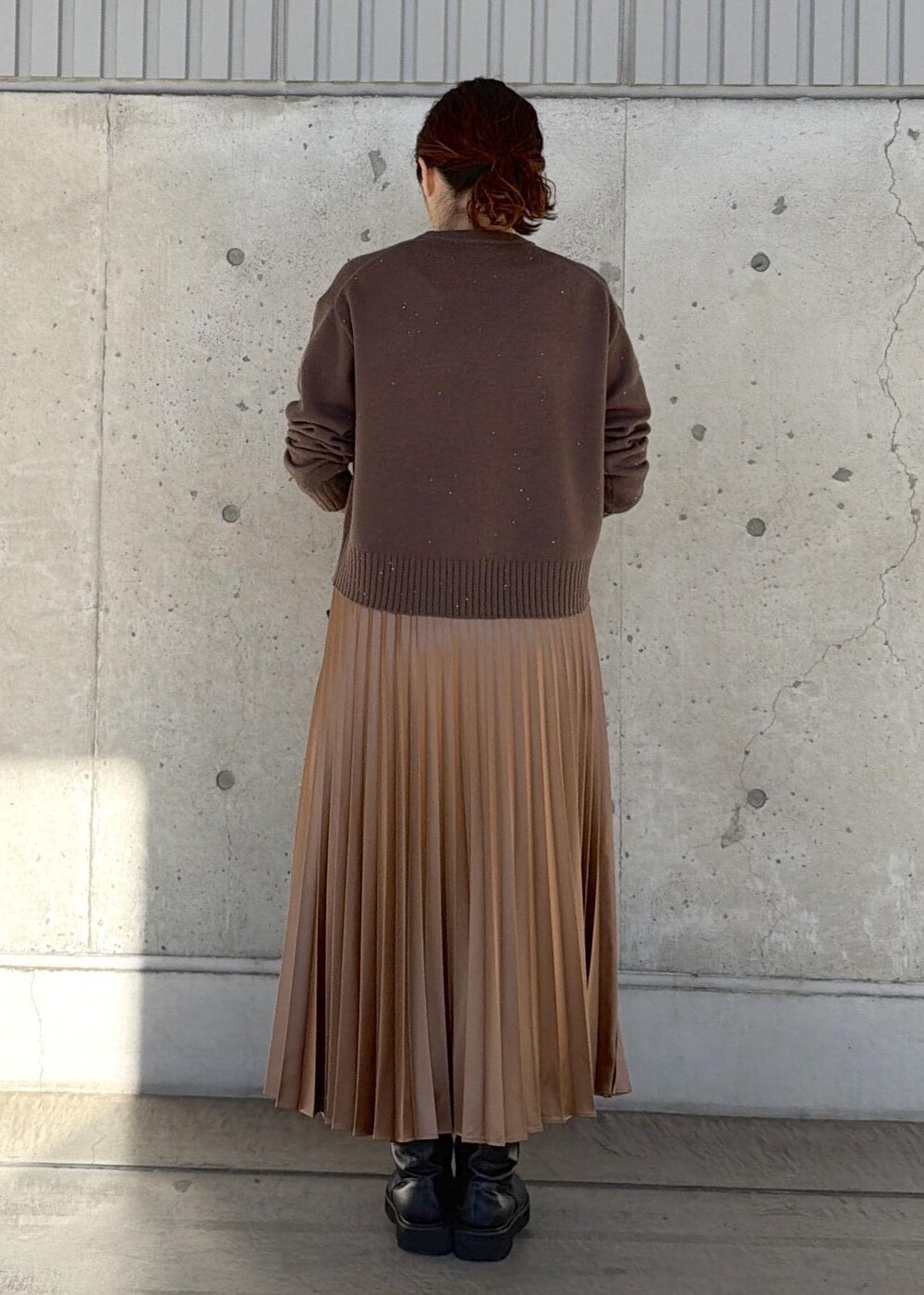 ブラック系のハンドバッグ、イエロー系のスカート、ブラウン系のニット/セーターを着用したレディースの冬コーディネートの3枚目の写真