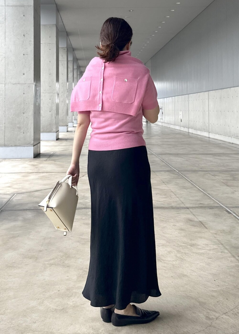 ブラック系のスカート、ピンク系のカーディガン/ボレロ、ピンク系のニット/セーターを着用したレディースの秋コーディネートの3枚目の写真