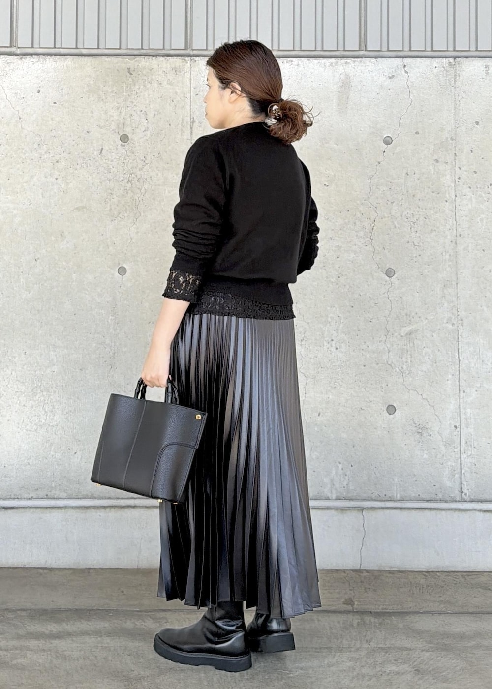 ブラック系のハンドバッグ、ブラック系のカーディガン/ボレロ、ブラック系のTシャツ/カットソーを着用したレディースの秋コーディネートの3枚目の写真