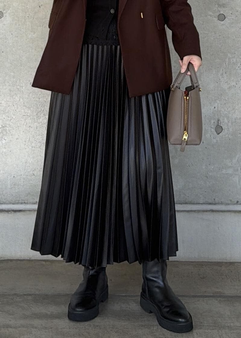 ブラウン系のハンドバッグ、ブラック系のカーディガン/ボレロ、ブラック系のスカートを着用したレディースの秋コーディネートの5枚目の写真