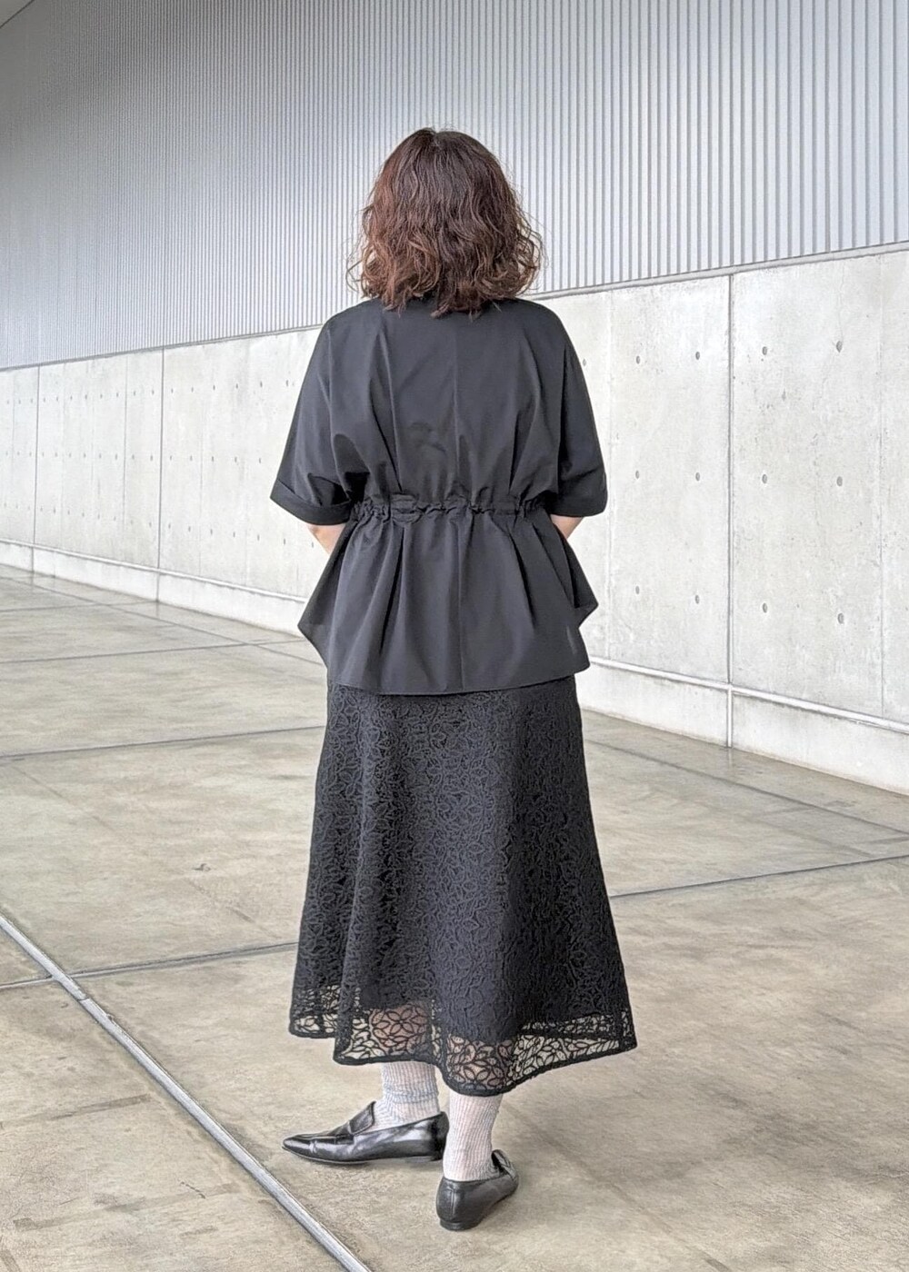 ブラック系のハンドバッグ、ブラック系のシャツ/ブラウス、ブラック系のスカートを着用したレディースの春コーディネートの3枚目の写真