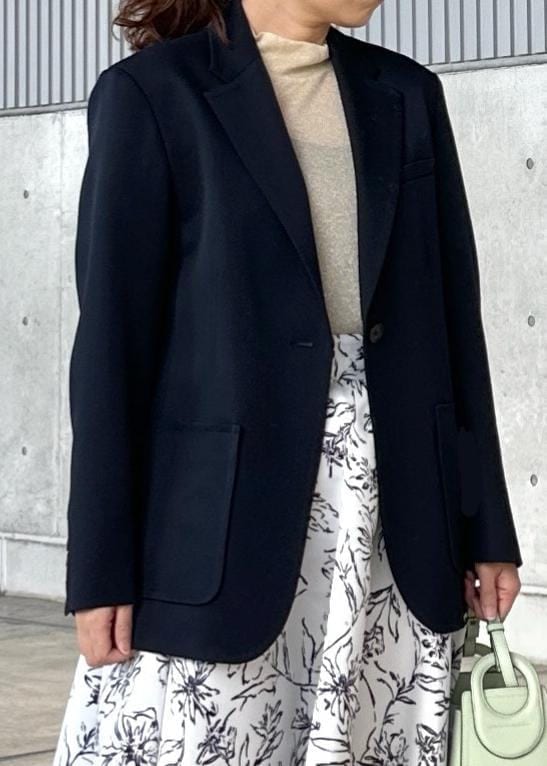 グリーン系のハンドバッグ、ホワイト系のスカート、ゴールド系のTシャツ/カットソーを着用したレディースの冬コーディネートの4枚目の写真