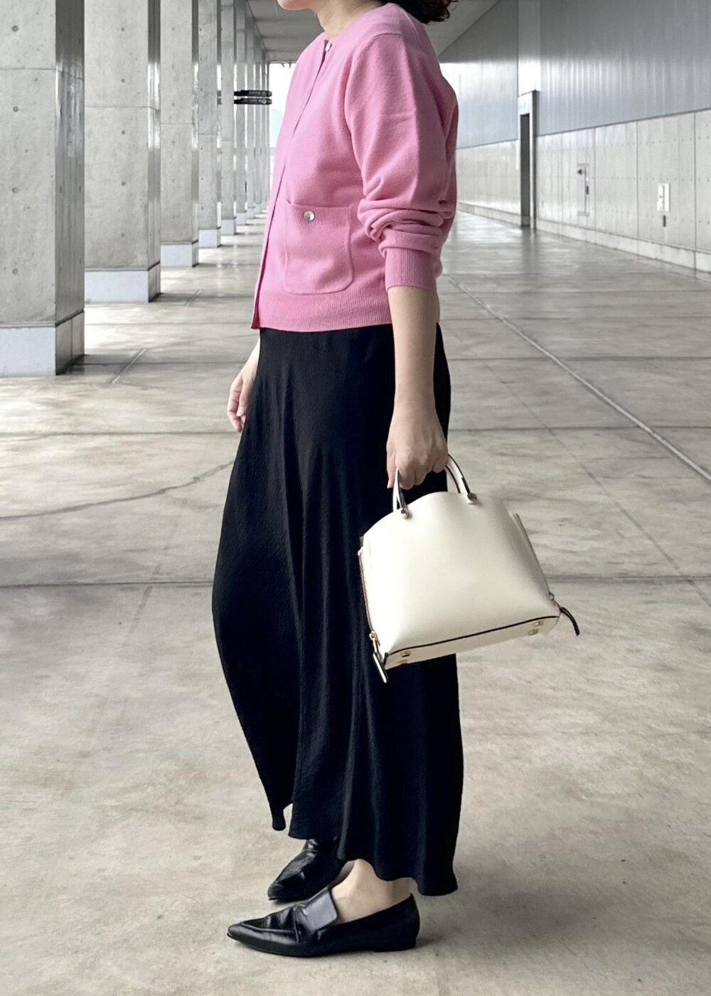 ブラック系のスカート、ピンク系のカーディガン/ボレロ、ピンク系のニット/セーターを着用したレディースの秋コーディネートの2枚目の写真