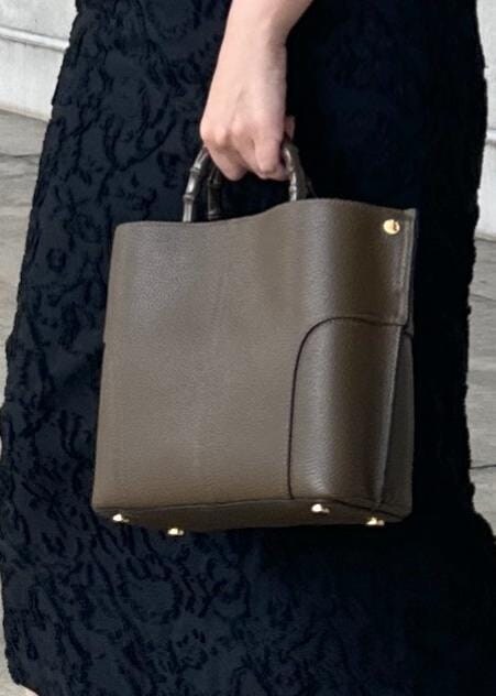 ホワイト系のTシャツ/カットソー、グリーン系のハンドバッグ、グレー系のベストを着用したレディースの秋コーディネートの6枚目の写真