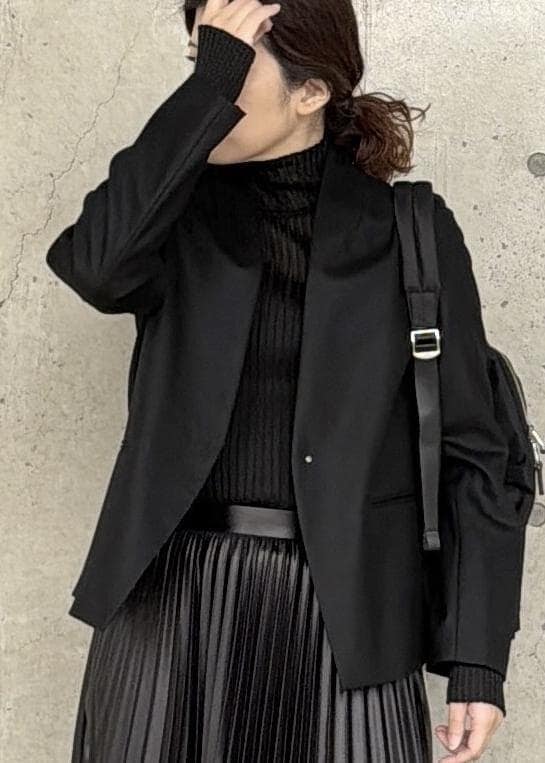 ブラック系のバックパック/リュック、ブラック系のスカート、ブラック系のニット/セーターを着用したレディースの冬コーディネートの4枚目の写真