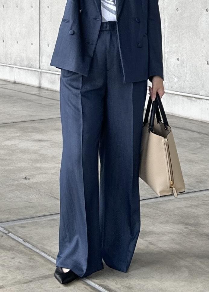 ベージュ系のトートバッグ、ブルー系のテーラードジャケット、ブルー系のその他パンツを着用したレディースの夏コーディネートの5枚目の写真