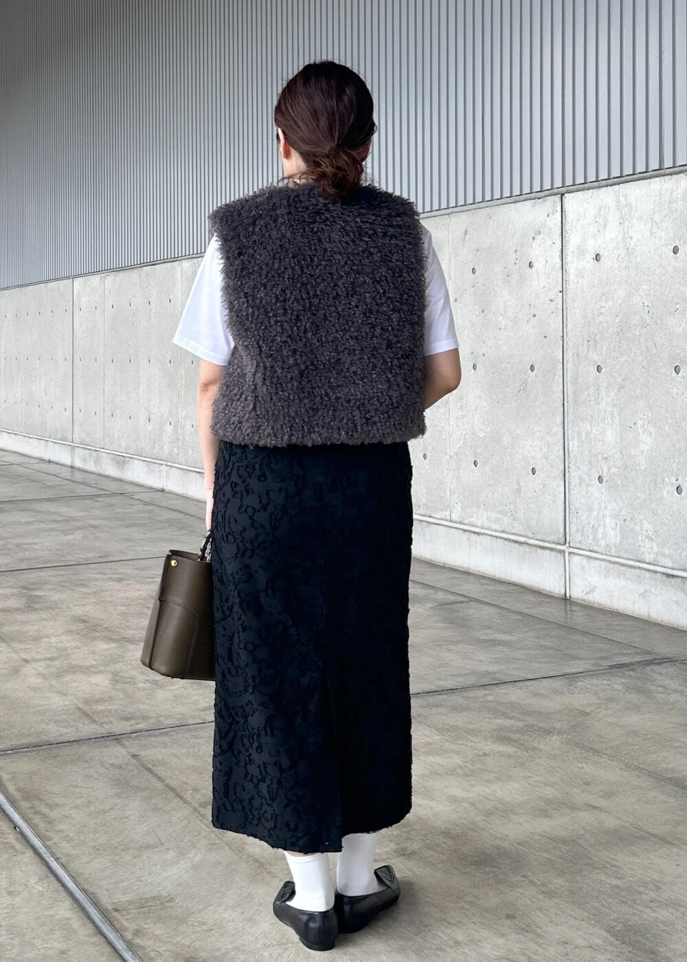 ホワイト系のTシャツ/カットソー、グリーン系のハンドバッグ、グレー系のベストを着用したレディースの秋コーディネートの3枚目の写真