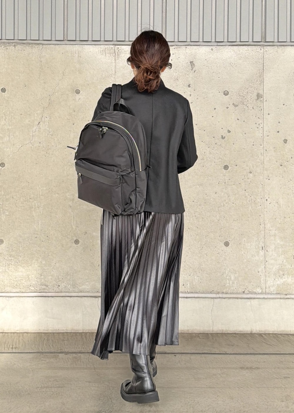 ブラック系のバックパック/リュック、ブラック系のスカート、ブラック系のニット/セーターを着用したレディースの冬コーディネートの3枚目の写真