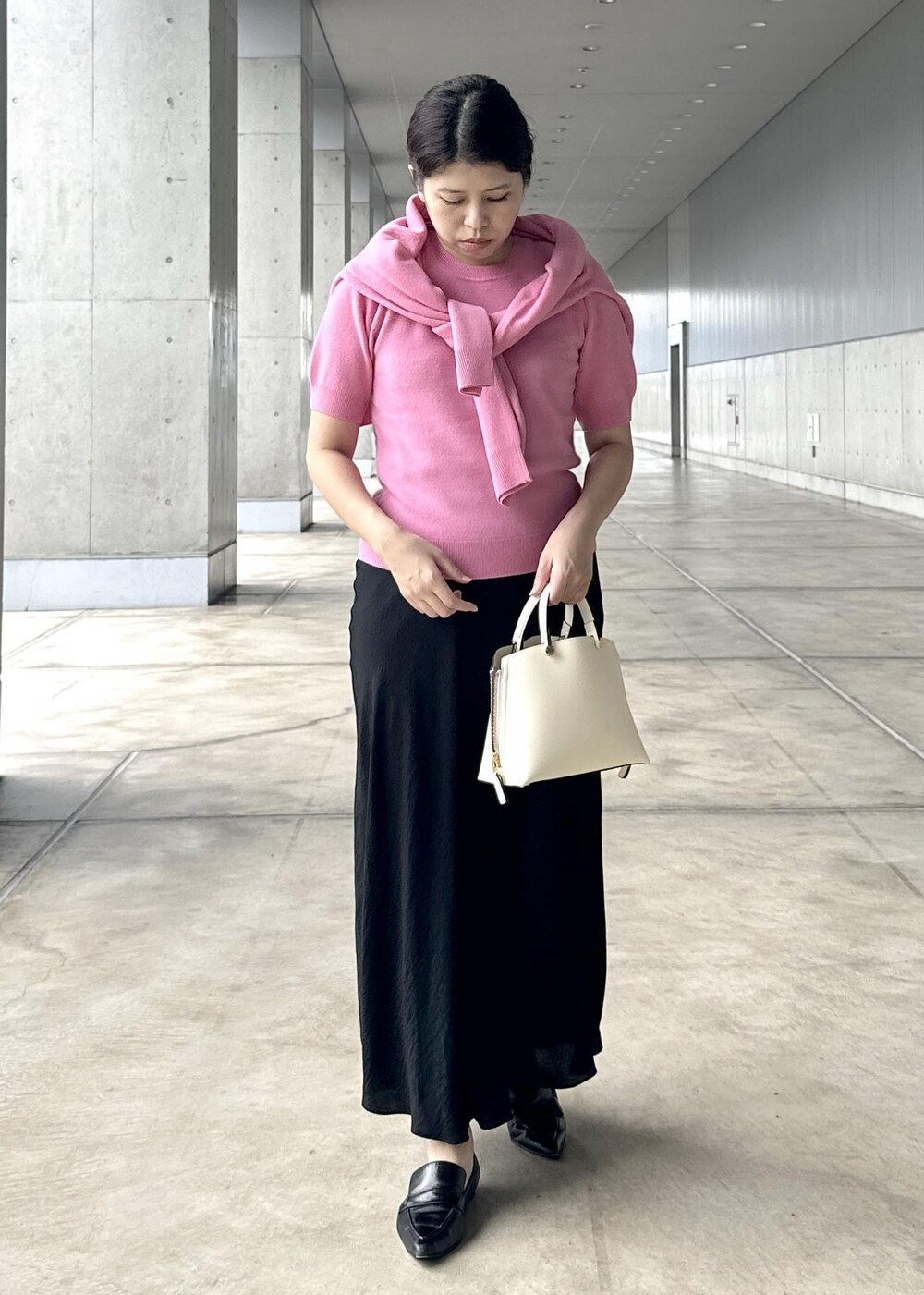 ブラック系のスカート、ピンク系のカーディガン/ボレロ、ピンク系のニット/セーターを着用したレディースの秋コーディネートの4枚目の写真