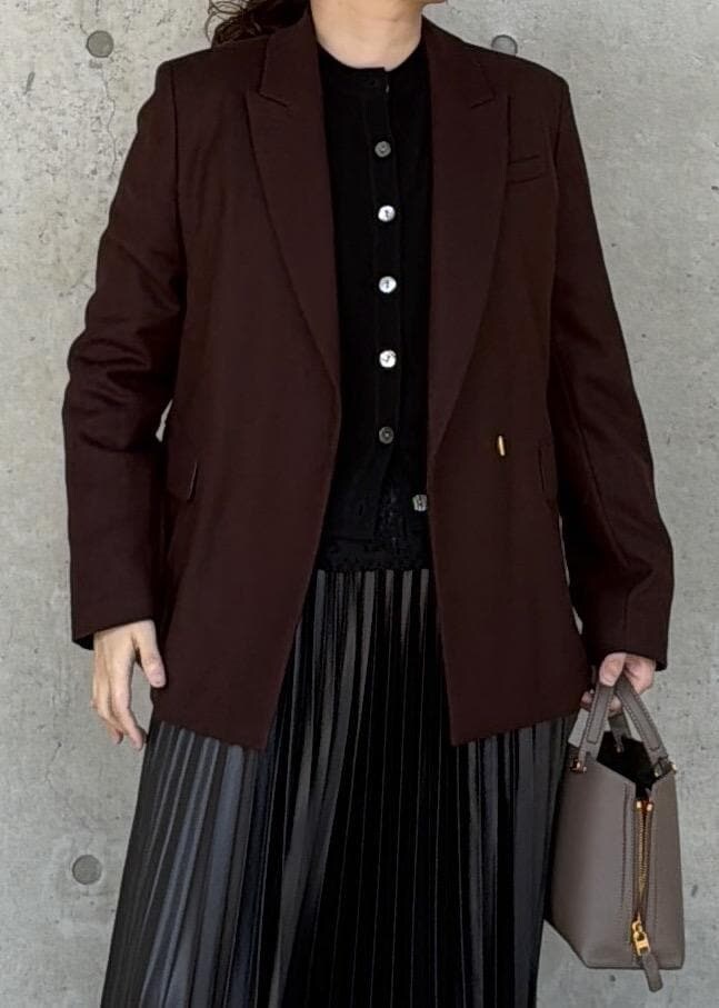 ブラウン系のハンドバッグ、ブラック系のカーディガン/ボレロ、ブラック系のスカートを着用したレディースの秋コーディネートの4枚目の写真