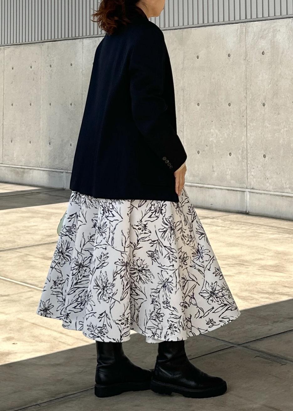 グリーン系のハンドバッグ、ホワイト系のスカート、ゴールド系のTシャツ/カットソーを着用したレディースの冬コーディネートの2枚目の写真