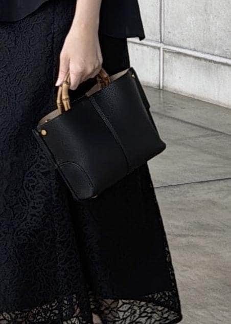 ブラック系のハンドバッグ、ブラック系のシャツ/ブラウス、ブラック系のスカートを着用したレディースの春コーディネートの6枚目の写真
