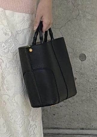 ブラック系のハンドバッグ、ホワイト系のTシャツ/カットソー、ホワイト系のその他パンツを着用したレディースの秋コーディネートの6枚目の写真