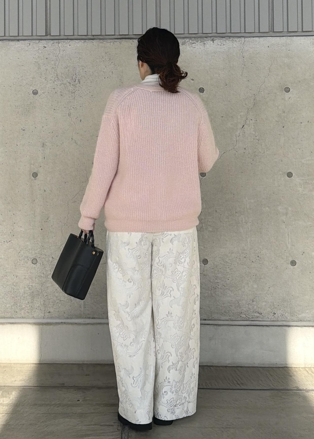 ブラック系のハンドバッグ、ホワイト系のTシャツ/カットソー、ホワイト系のその他パンツを着用したレディースの秋コーディネートの3枚目の写真