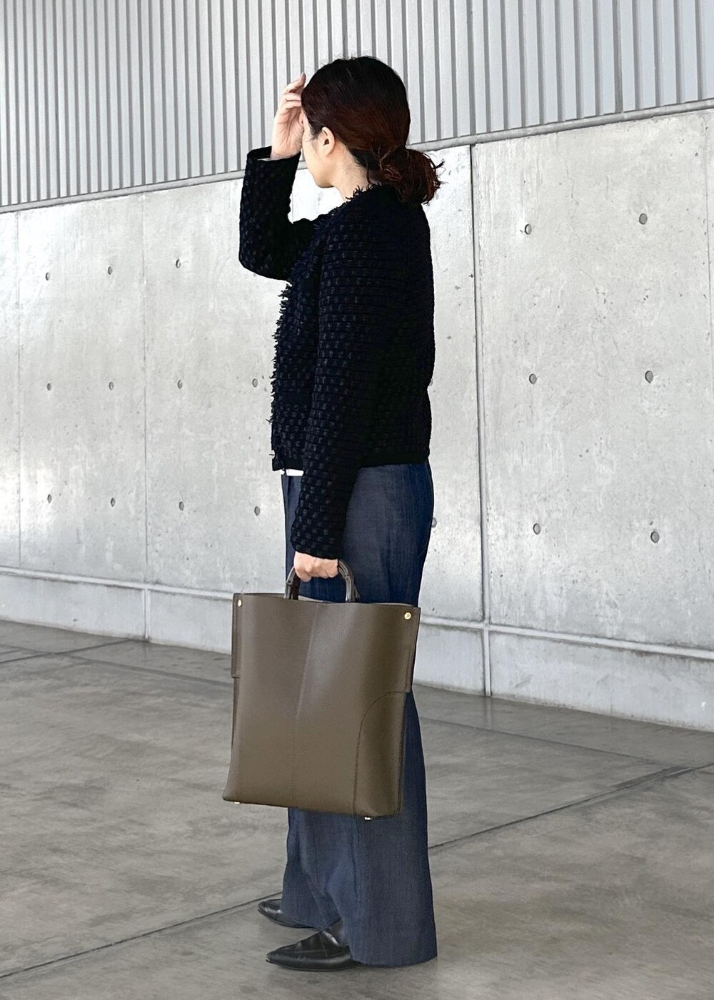 グリーン系のトートバッグ、ブルー系のその他パンツ、ホワイト系のTシャツ/カットソーを着用したレディースの秋コーディネートの2枚目の写真