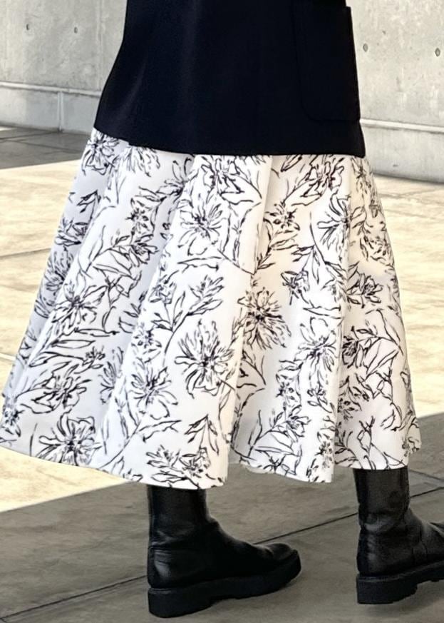 グリーン系のハンドバッグ、ホワイト系のスカート、ゴールド系のTシャツ/カットソーを着用したレディースの冬コーディネートの5枚目の写真