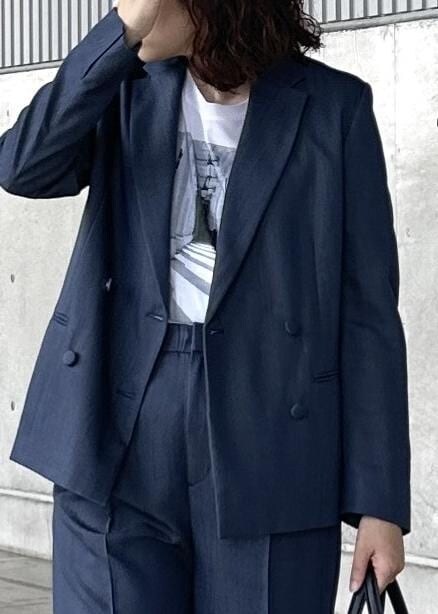 ベージュ系のトートバッグ、ブルー系のテーラードジャケット、ブルー系のその他パンツを着用したレディースの夏コーディネートの4枚目の写真