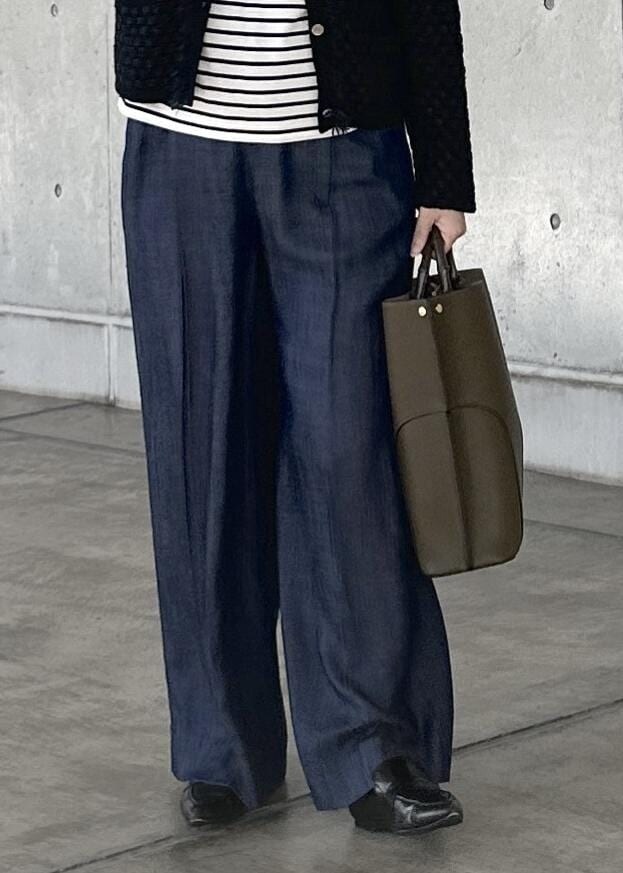 グリーン系のトートバッグ、ブルー系のその他パンツ、ホワイト系のTシャツ/カットソーを着用したレディースの秋コーディネートの6枚目の写真