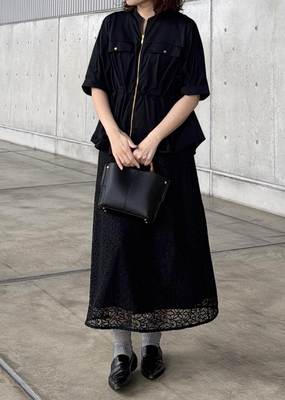 ブラック系のハンドバッグ、ブラック系のシャツ/ブラウス、ブラック系のスカートを着用したレディースの春コーディネートの7枚目の写真