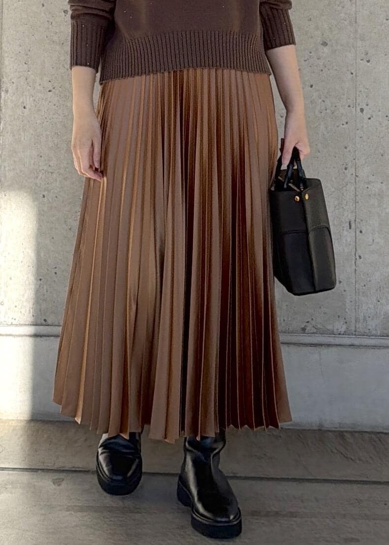 ブラック系のハンドバッグ、イエロー系のスカート、ブラウン系のニット/セーターを着用したレディースの冬コーディネートの5枚目の写真