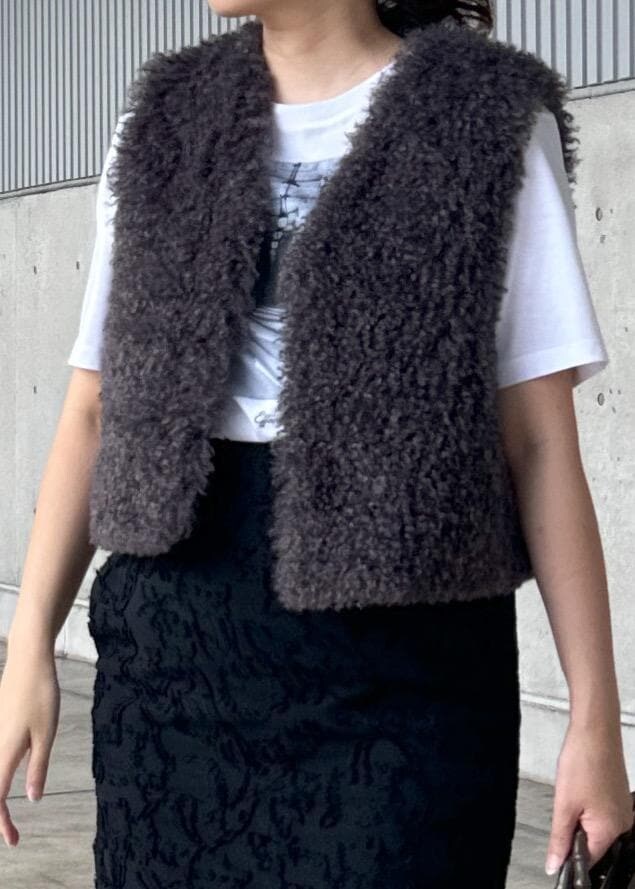 ホワイト系のTシャツ/カットソー、グリーン系のハンドバッグ、グレー系のベストを着用したレディースの秋コーディネートの4枚目の写真