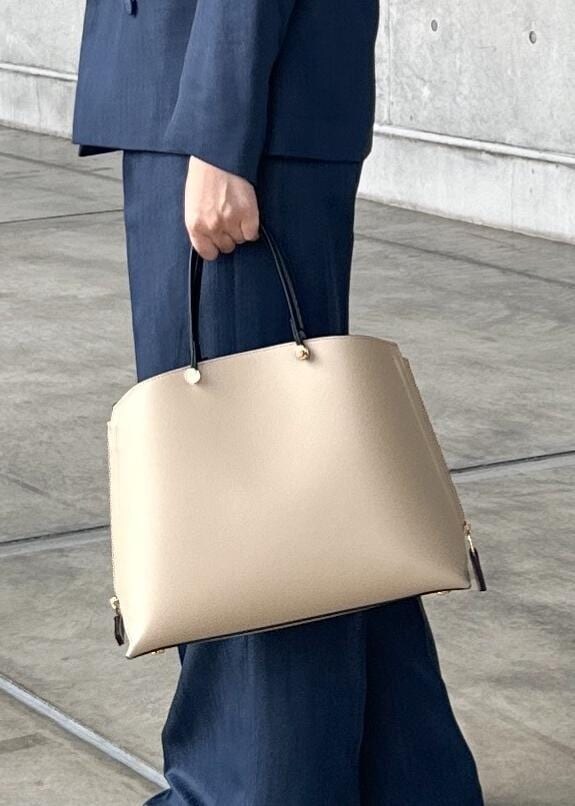 ベージュ系のトートバッグ、ブルー系のテーラードジャケット、ブルー系のその他パンツを着用したレディースの夏コーディネートの6枚目の写真