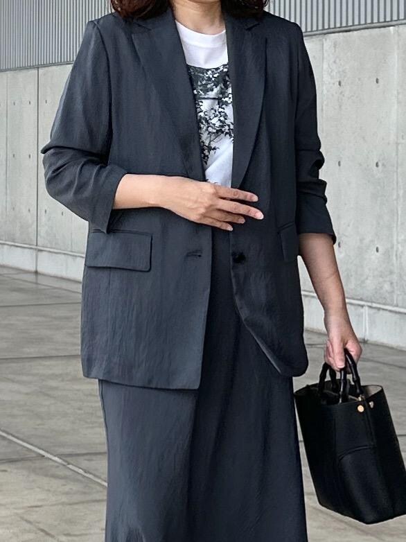 ホワイト系のTシャツ/カットソー、グレー系のスカート、グレー系のテーラードジャケットを着用したレディースの秋コーディネートの4枚目の写真