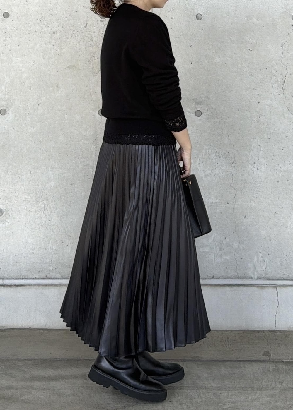 ブラック系のハンドバッグ、ブラック系のカーディガン/ボレロ、ブラック系のTシャツ/カットソーを着用したレディースの秋コーディネートの2枚目の写真