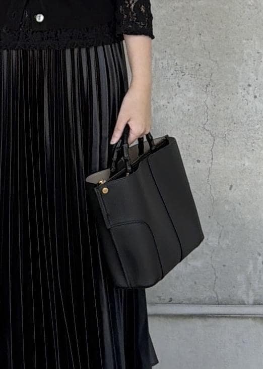 ブラック系のハンドバッグ、ブラック系のカーディガン/ボレロ、ブラック系のTシャツ/カットソーを着用したレディースの秋コーディネートの6枚目の写真