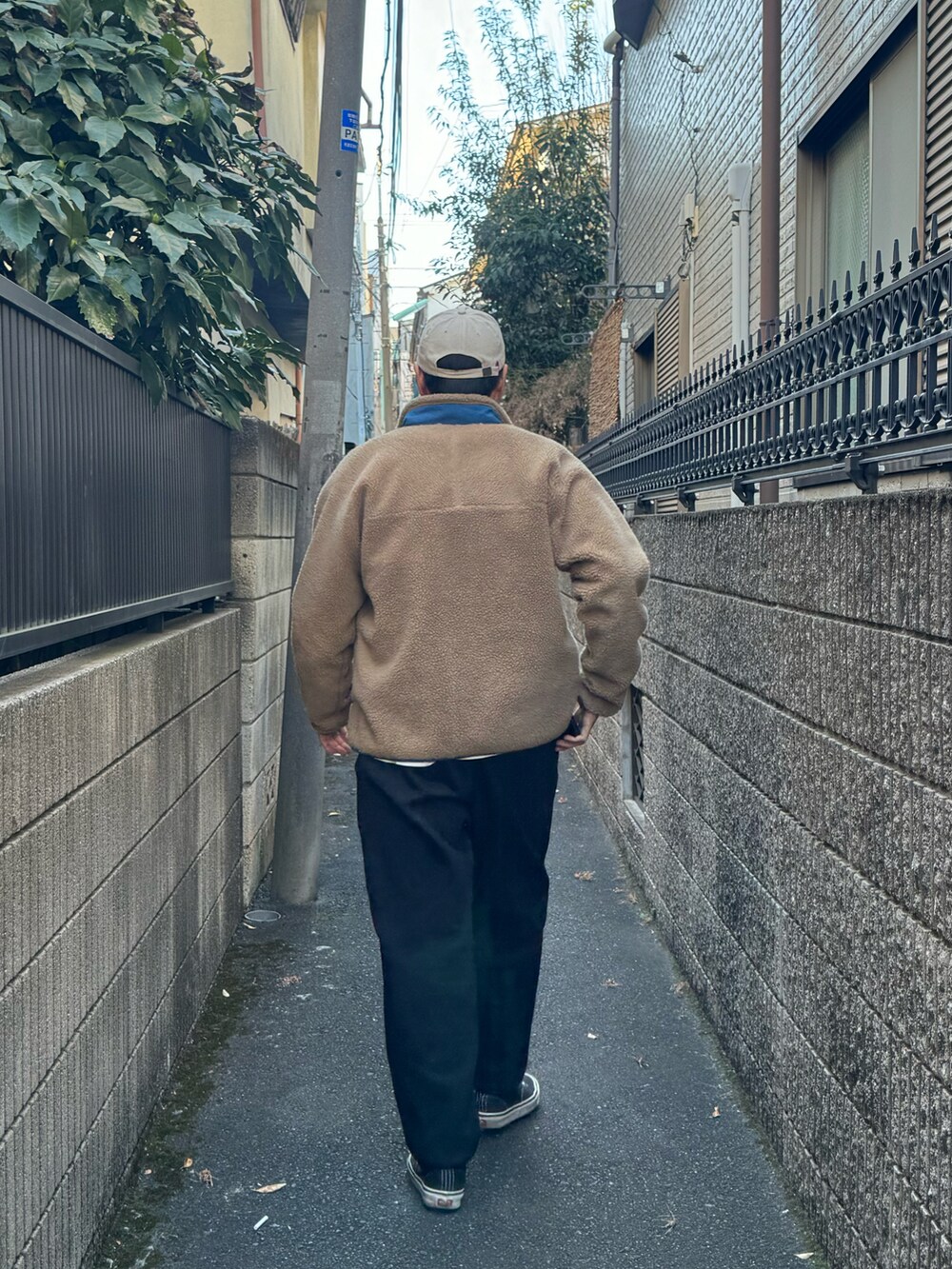 ベージュ系のブルゾン、ブラック系のニット/セーター、ブラック系のスウェットパンツを着用したレディースの冬コーディネートの2枚目の写真