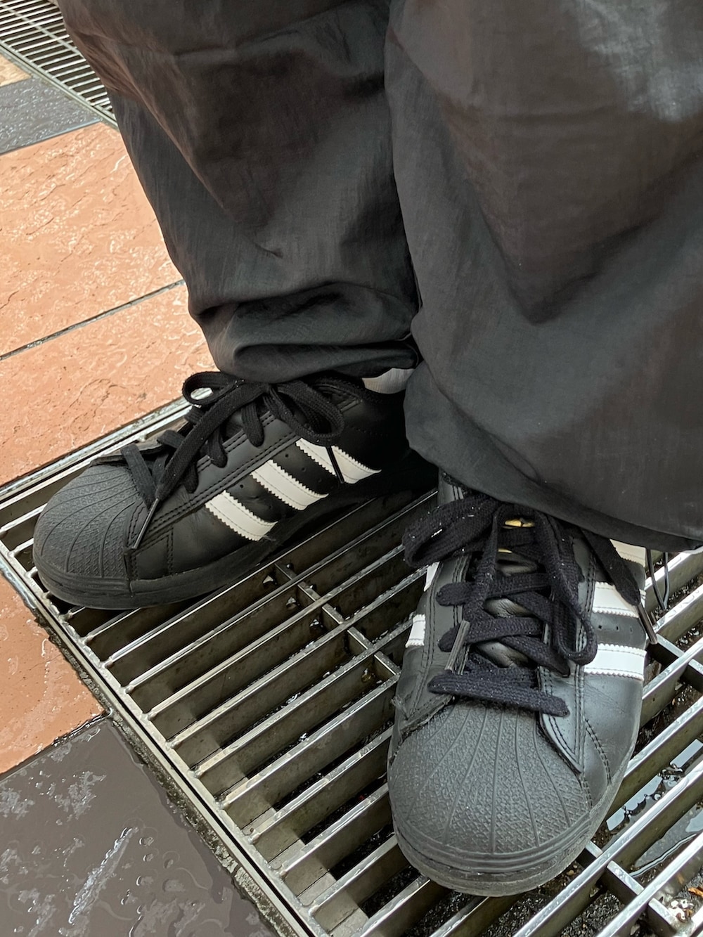 ホワイト系のナイロンジャケット、ブラック系のパンツ、ブラック系のスニーカーを着用したレディースの春コーディネートの6枚目の写真