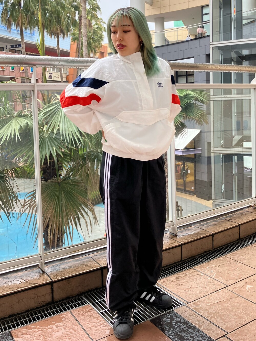 ホワイト系のナイロンジャケット、ブラック系のパンツ、ブラック系のスニーカーを着用したレディースの春コーディネートの3枚目の写真