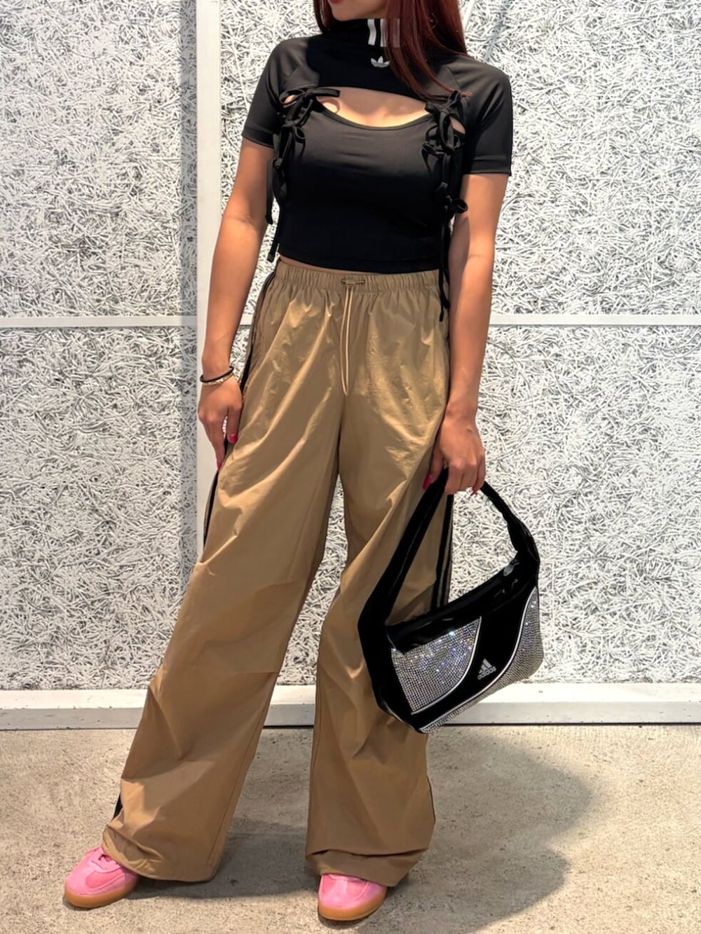 ピンク系のスニーカー、ブラック系のTシャツ/カットソー、ブラウン系のパンツを着用したレディースの夏コーディネートの2枚目の写真