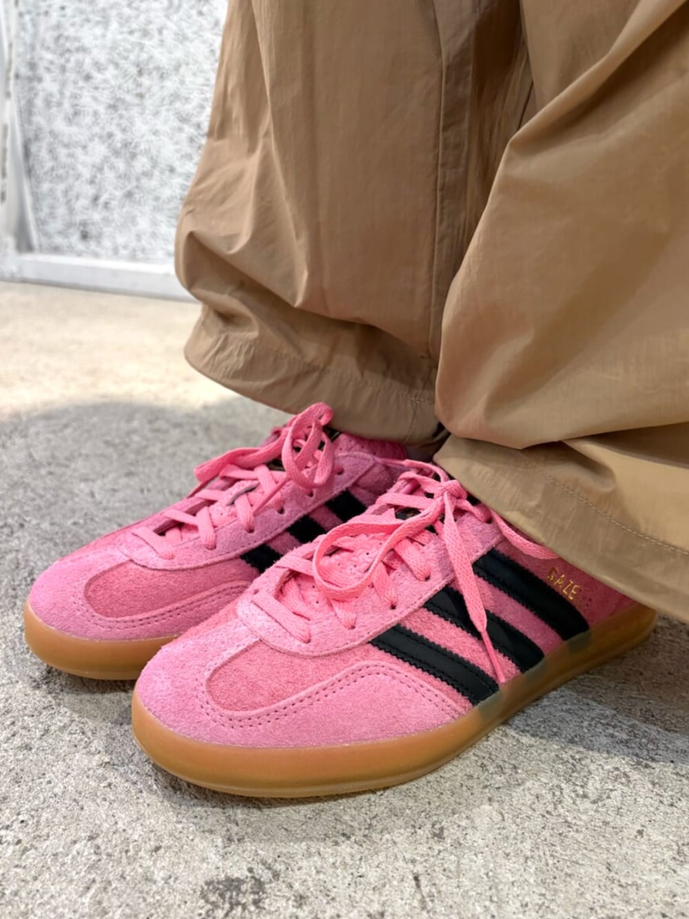 ピンク系のスニーカー、ブラック系のTシャツ/カットソー、ブラウン系のパンツを着用したレディースの夏コーディネートの5枚目の写真