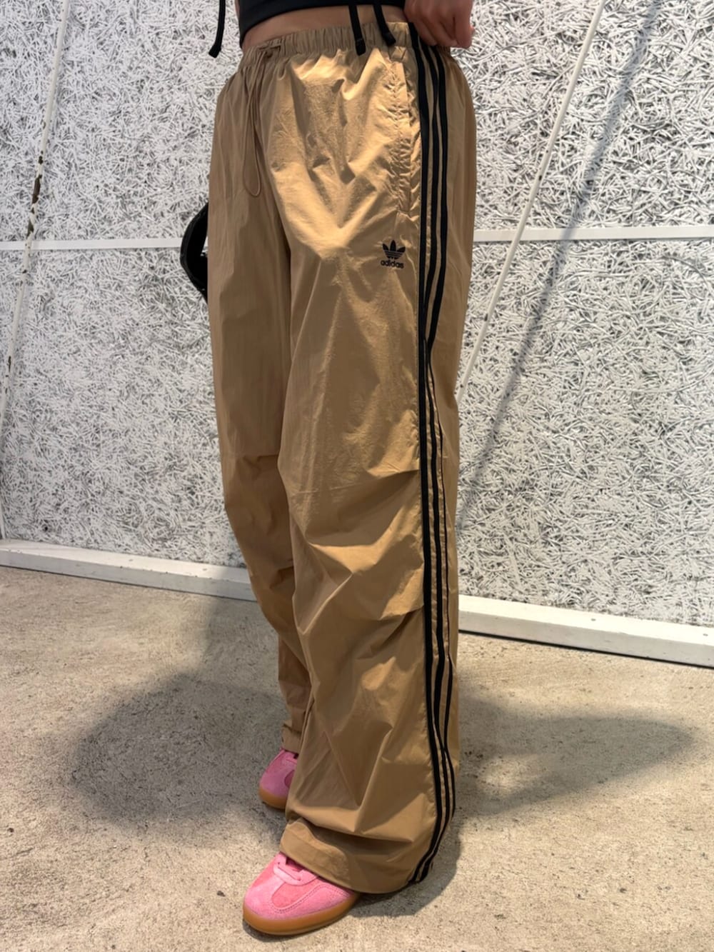 ピンク系のスニーカー、ブラック系のTシャツ/カットソー、ブラウン系のパンツを着用したレディースの夏コーディネートの4枚目の写真