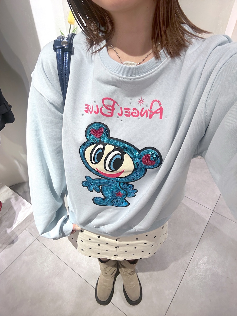 ブルー系のTシャツ/カットソー、ブルー系のボストンバッグ、ホワイト系のスカートを着用したレディースの春コーディネートの5枚目の写真