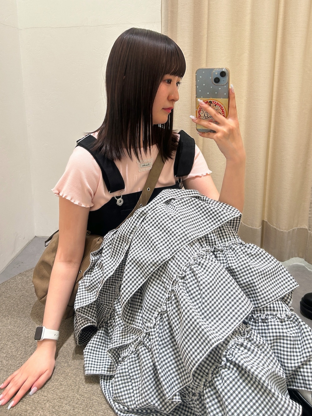 ピンク系のTシャツ/カットソー、ブラウン系のトートバッグ、ブラック系のジャンパースカートを着用したレディースの春コーディネートの3枚目の写真