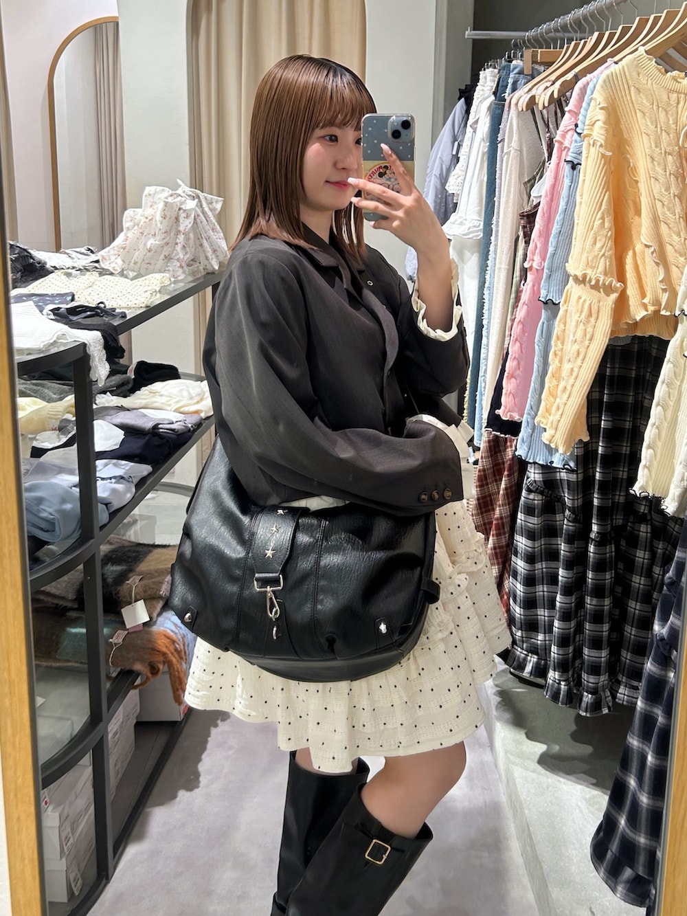 グレー系のテーラードジャケット、ブラック系のトートバッグ、ホワイト系のワンピースを着用したレディースの春コーディネートの2枚目の写真