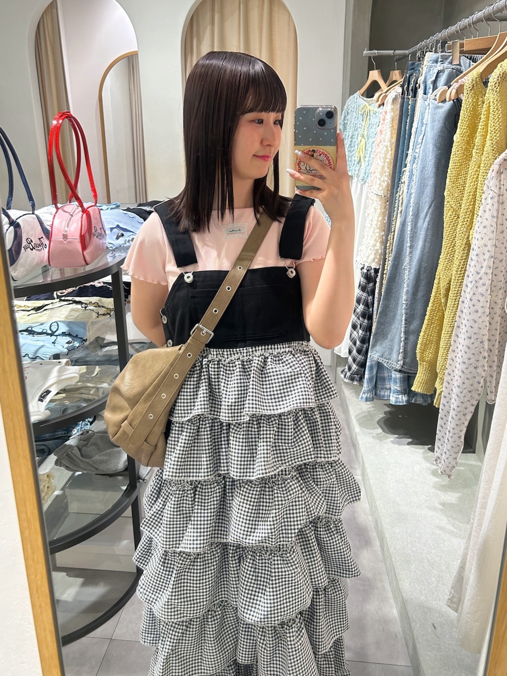 ピンク系のTシャツ/カットソー、ブラウン系のトートバッグ、ブラック系のジャンパースカートを着用したレディースの春コーディネートの2枚目の写真