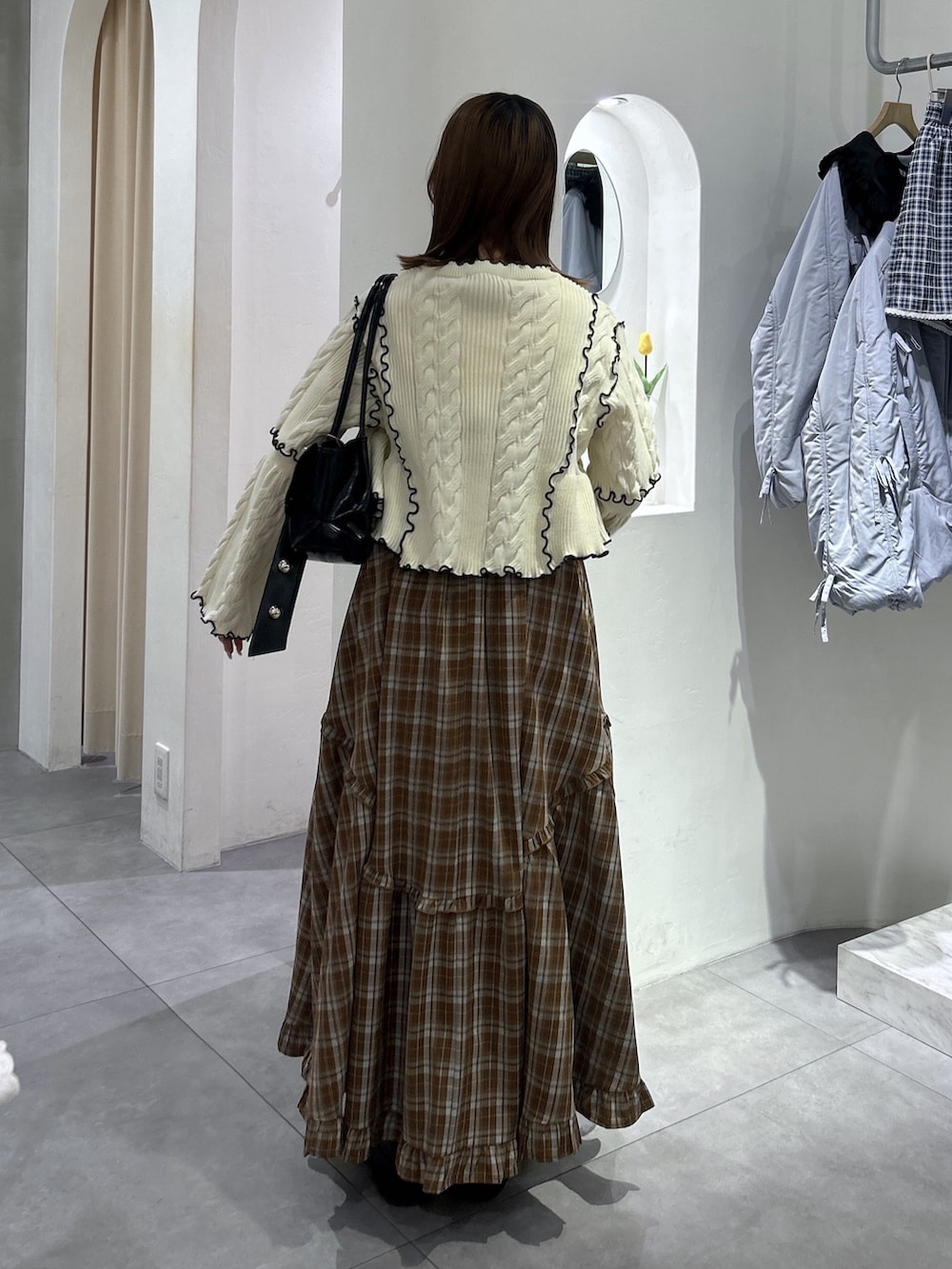 ホワイト系のカーディガン/ボレロ、ブラウン系のワンピース、ブラック系のトートバッグを着用したレディースの春コーディネートの3枚目の写真