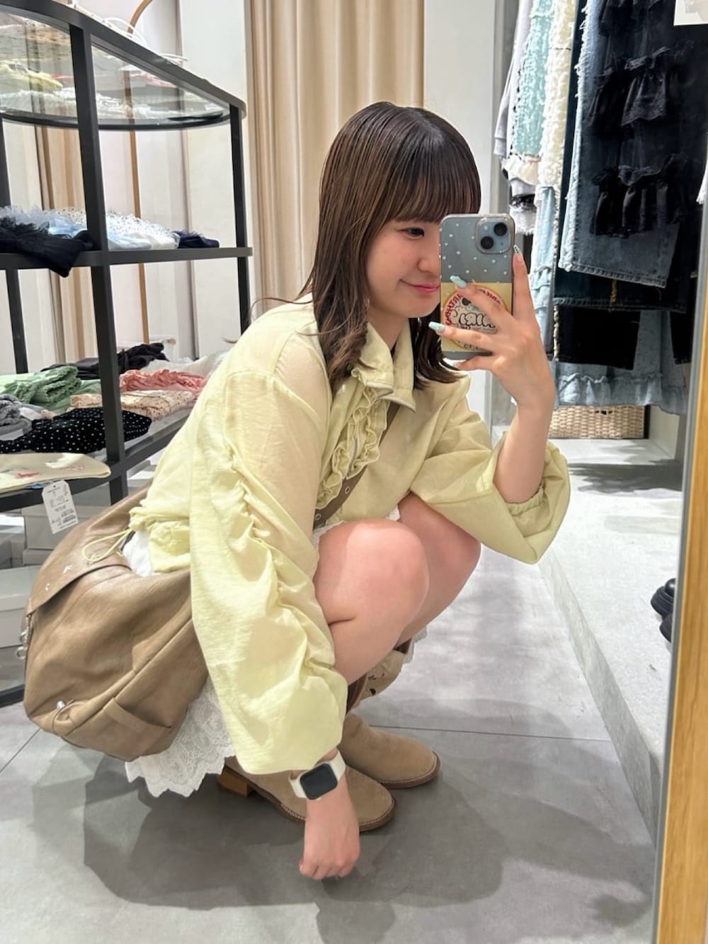 イエロー系のブルゾン、ブラウン系のトートバッグ、ホワイト系のその他パンツを着用したレディースの夏コーディネートの2枚目の写真
