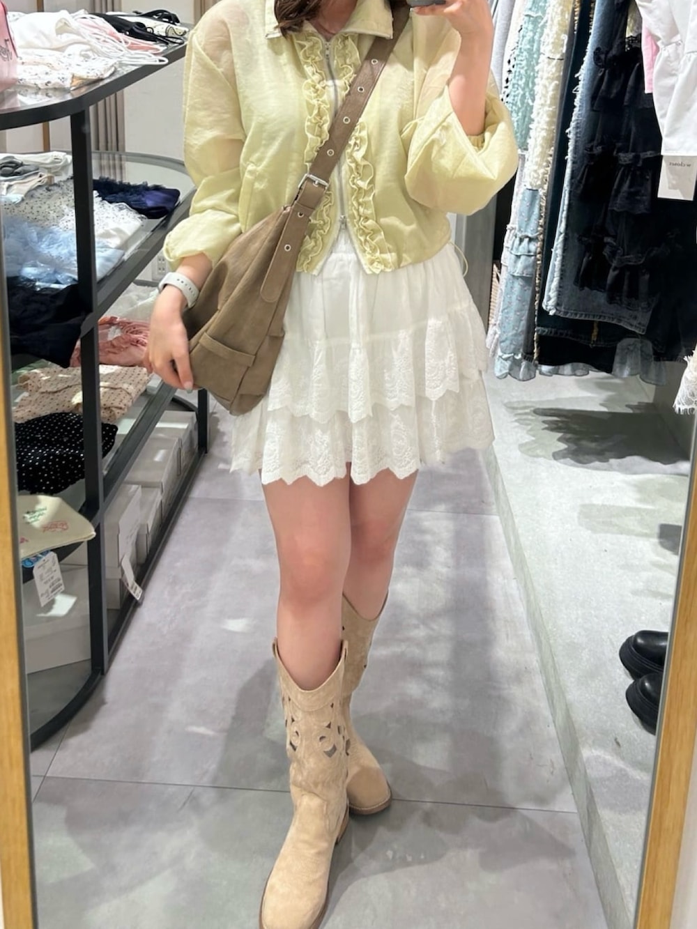 イエロー系のブルゾン、ブラウン系のトートバッグ、ホワイト系のその他パンツを着用したレディースの夏コーディネートの4枚目の写真
