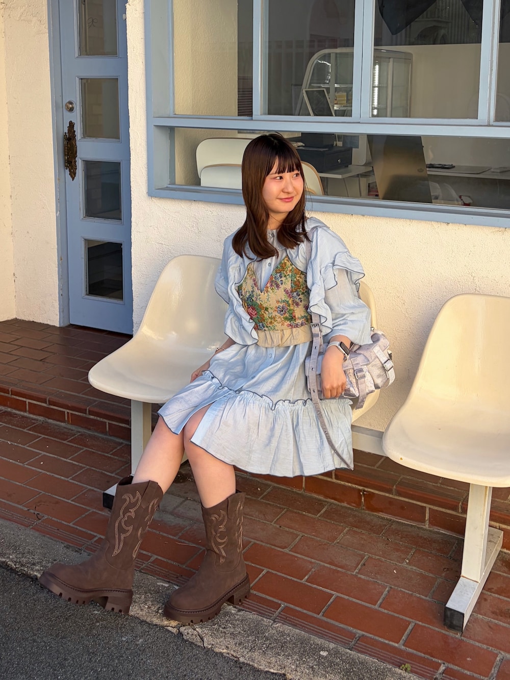 ベージュ系のその他トップス、ブルー系のシャツ/ブラウス、ブラウン系のブーツを着用したレディースの夏コーディネートの2枚目の写真